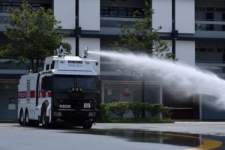 Kepolisian Hong Kong mendemonstrasikan penggunaan kendaraan meriam air di kompleks Unit Taktis Polisi di Hong Kong, Senin (12/8/2019).