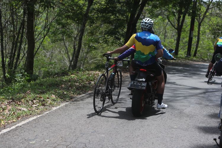Salah satu peserta Cycling De Jabar yang tidak sanggup lagi sehingga harus dievakuasi saat melalui jalur tanjakan di Ciletuh, Sukabumi, Jawa Barat, Sabtu (27/8/2022).