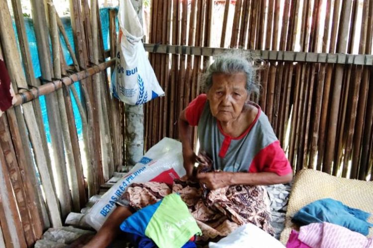 Habsah (75) melipat pakaian di gubuk berdinding pelepah rumbia di Desa Seunubok Baro, Kecamatan Cot Girek, Kabupaten Aceh Utara, Minggu (23/9/2018)