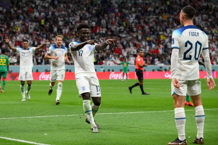 Winger timnas Inggris Bukayo Saka (tengah) merayakan golnya ke gawang Senegal bersama Phil Foden pada laga babak 16 besar Piala Dunia 2022 di Stadion Al Bayt, Al Khor, Qatar, Senin (5/12/2022) dini hari WIB. Inggris mampu mengakhiri laga kontra Senegal dengan skor 3-0. Selanjutnya, mereka akan melawan Perancis pada perempat final Piala Dunia 2022. Artikel ini berisi link live streaming Italia vs Inggris.