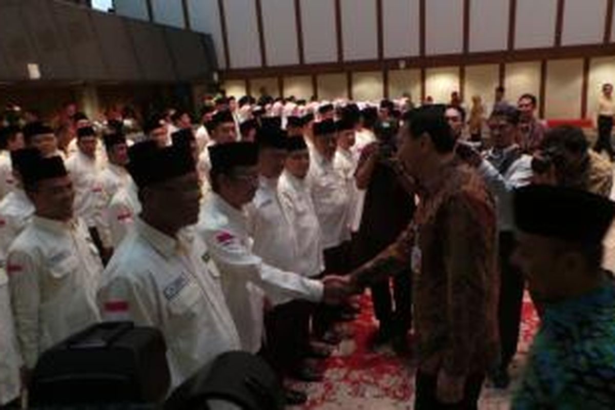Gubernur DKI Jakarta Basuki Tjahaja Purnama menyalami mantan Wali Kota Jakarta Selatan Syamsuddin Noor seusai mengukuhkan petugas pendaming jamaah haji tahun 2015, di Balai Kota, Kamis (13/8/2015). 