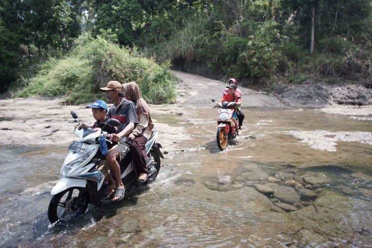 Warga Desa Tenjolaut, Kabupaten Sukabumi saat menerobos aliran sungai Cikidang.