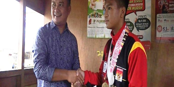 Mantan Bupati Nias Selatan, Idealisman Dachi, memberikan bonus Rp 3 juta kepada Eben Setiawan Harefa, peraih medali perak dati South East Asia Karate Federation (SEAKF), yang digelar di Semarang, awal Mei 2017.