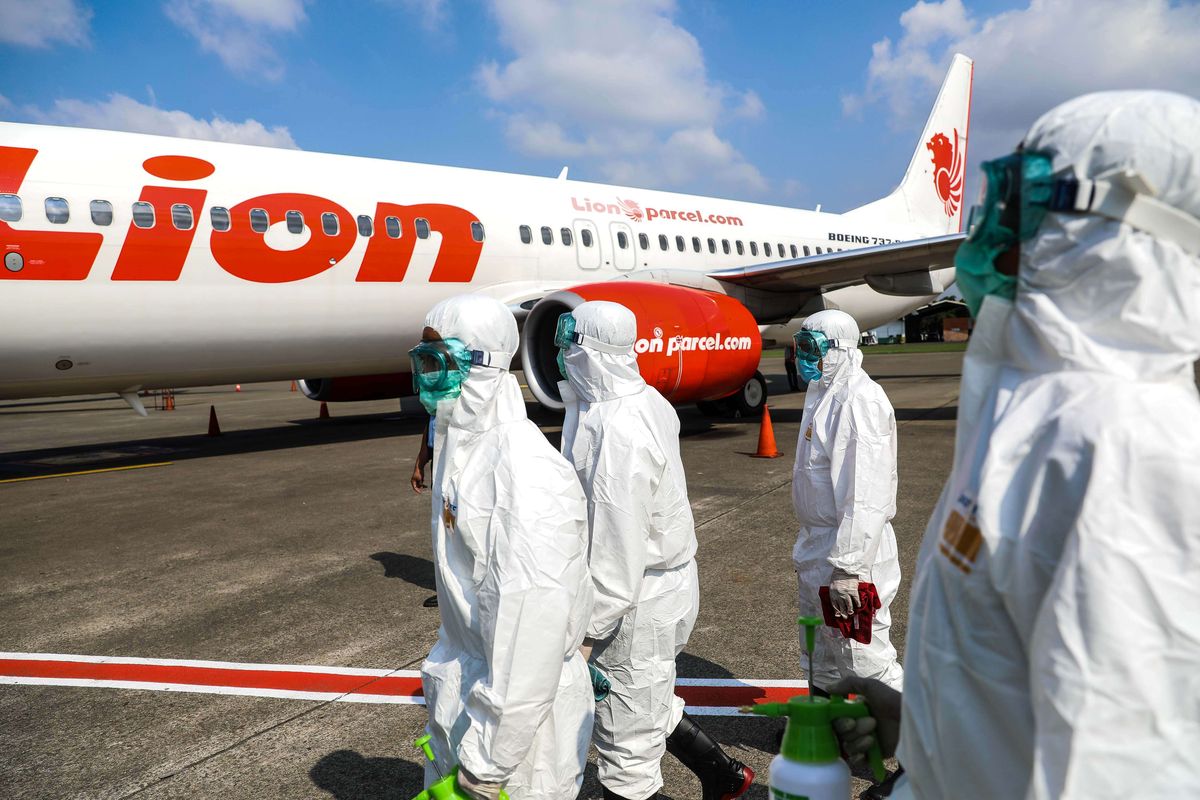 Petugas kebersihan bandara disamping pesawat Lion Air Boeing 737-800 setelah melakukan sterilisasi di Bandara Soekarno Hatta, Tangerang, Banten (17/3/2020). Lion Air Grup melakukan sterilisasi pesawat sebagai langkah pencegahan dalam menghadapi wabah penyakit akibat virus Covid-19.