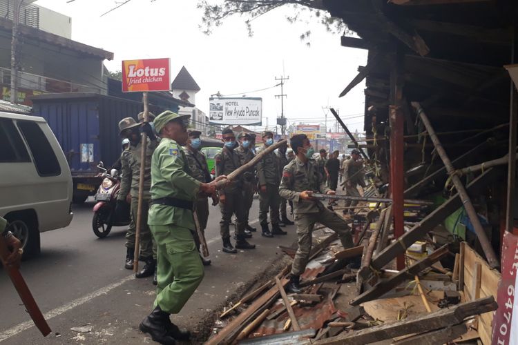 Sejumlah petugas Satpol PP Kabupaten Bogor merobohkan salah satu lapak PKL di Jalan Raya Puncak, Selasa (5/9/2017).