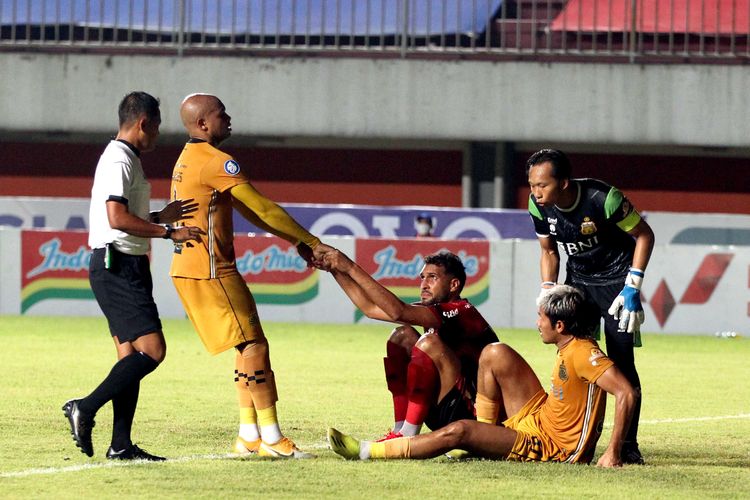 Pemain Bhayangkara FC Anderson Salles membantu pemain Bali United Willian Pachecho yang terjatuh berebut bola saat pertandingan yang berakhir dengan skor 1-2 pada pekan 8 Liga 1 2021 di Stadion Maguwoharjo Sleman, Sabtu (23/10/2021) malam.