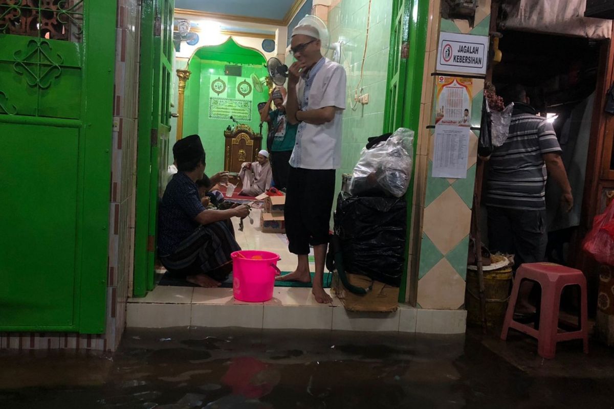 Warga Kampung Guji Baru, Duri Kepa, Kebon Jeruk, Jakarta Barat, pasrah ketika permukimannya terendam banjir sejak Selasa (5/4/2022) sore. 