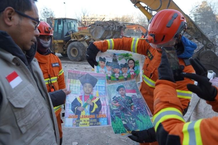 A Search and Rescue team member looks at pictures of children suspected of falling victim to the Turkey earthquake. 