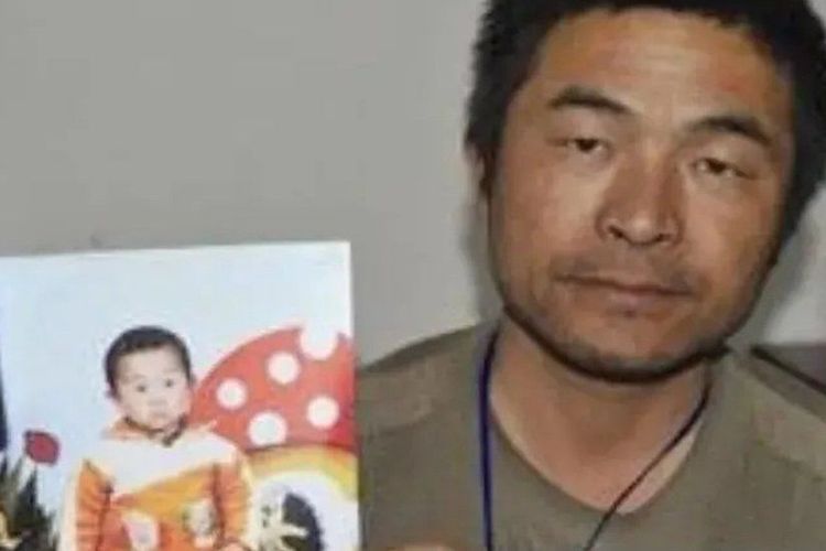 Guo Gangtang sedang memegang foto putranya pada 24 tahun silam yang diculik. [Weibo Via BBC]