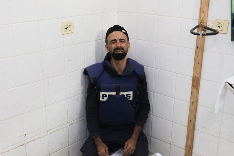 Jurnalis di Gaza, Mohammed Alaloul, meratapi jenazah putranya yang tewas dalam serangan Israel ke kamp pengungsi Al Maghazi di Deir Balah, Jalur Gaza tengah. Jenazah putranya berada di rumah sakit Al Quds, Gaza, Minggu (5/11/2023).