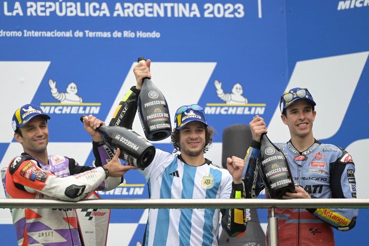 Marco Bezzecchi menggunakan kostum timnas Argentina bertanda tangan Lionel Messi usai menjadi pemenang MotoGP Argentina 2023 di Sirkuit Termas de Rio Hondo, Senin (3/4/2023) dini hari WIB. (Foto oleh JUAN MABROMATA / AFP)