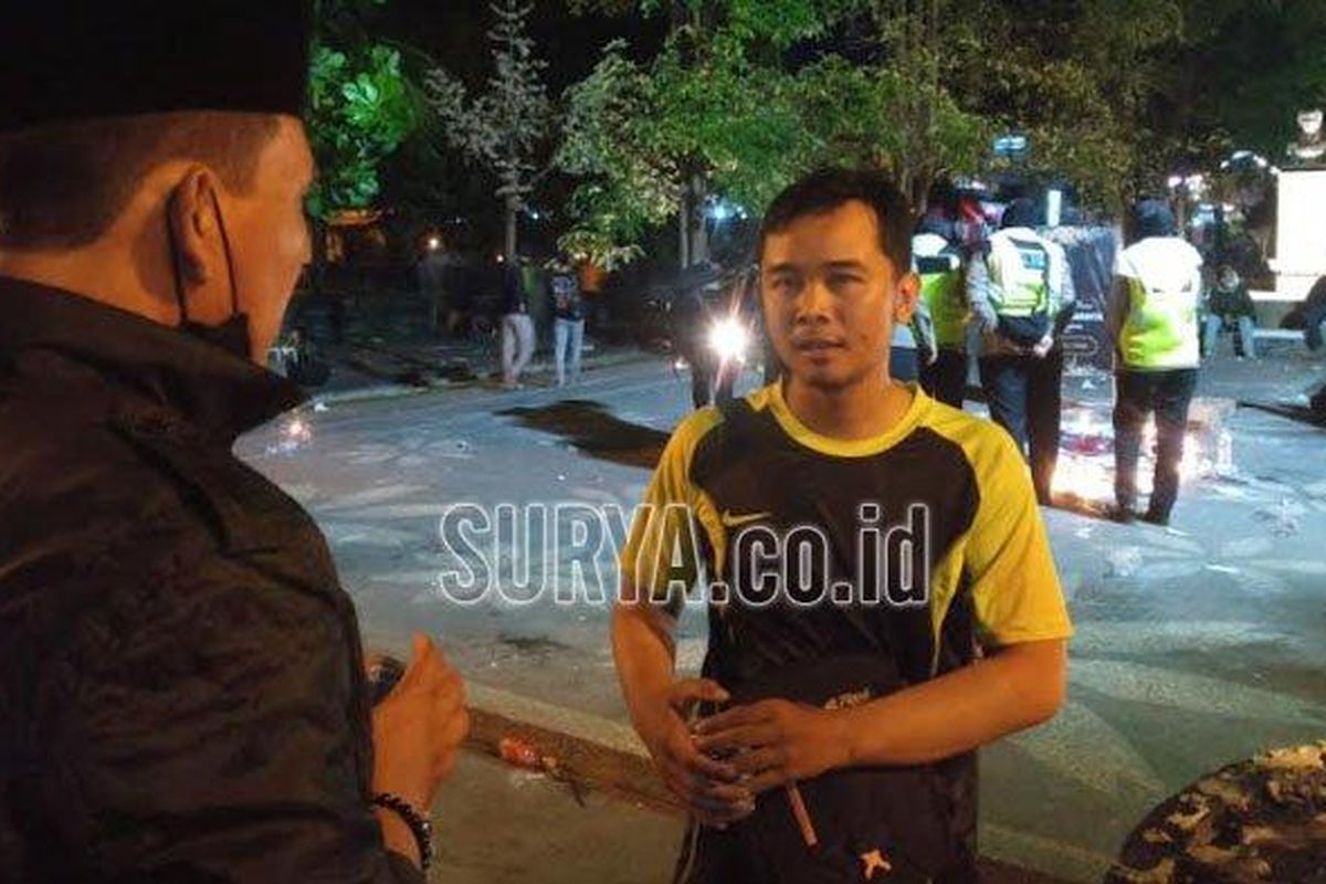 Bimo (23) usai menghadiri aksi keprihatinan Tragedi Kanjuruhan, Selasa (4/10/2022) malam. (Surya.co.id/David Yohanes)