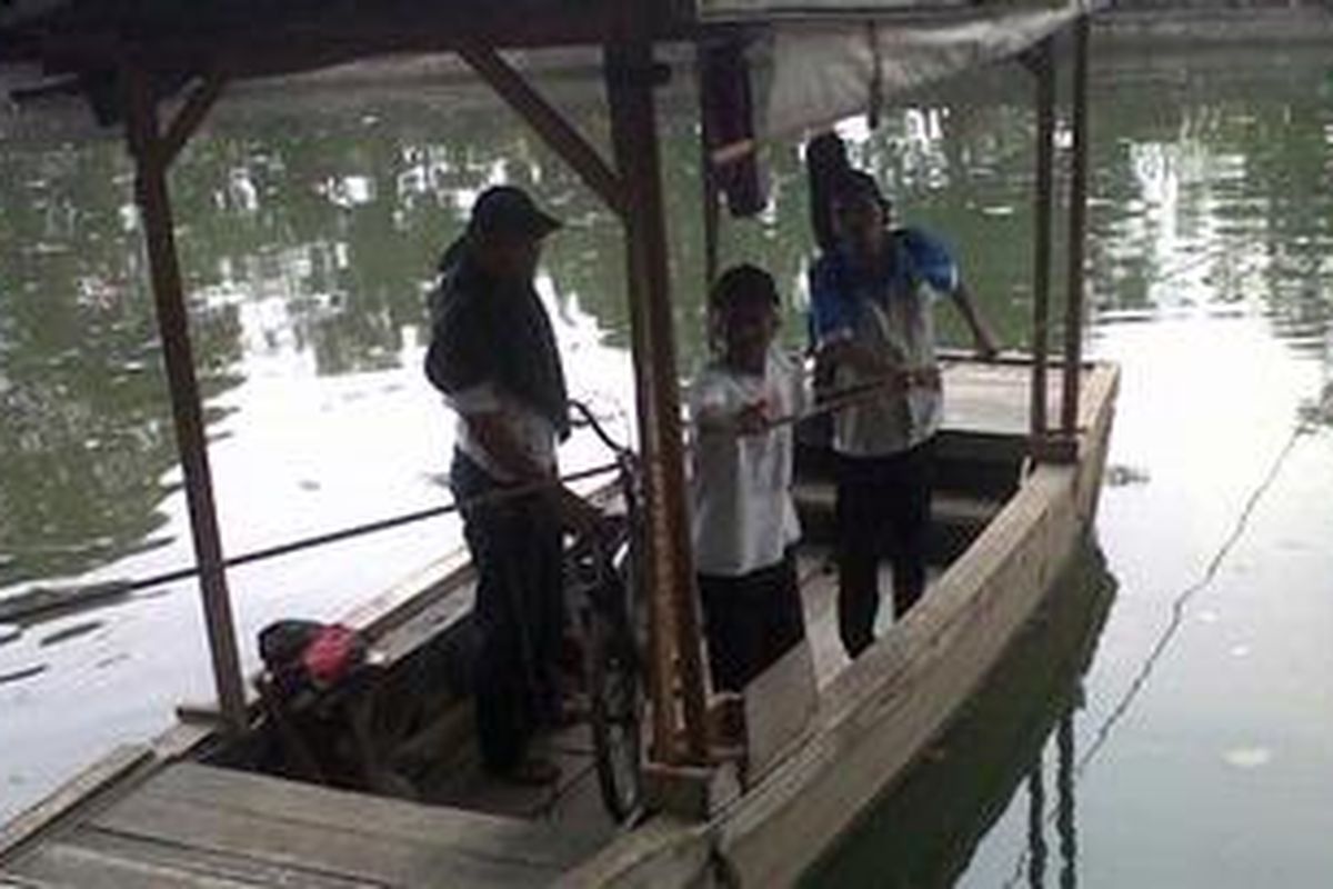 Mukhtar (64) penarik perahu eretan saat tengah menghantar penumpangnya menyebrangi kali Sunter, Koja, Jakarta Utara. Jumat (19/10/2012). 