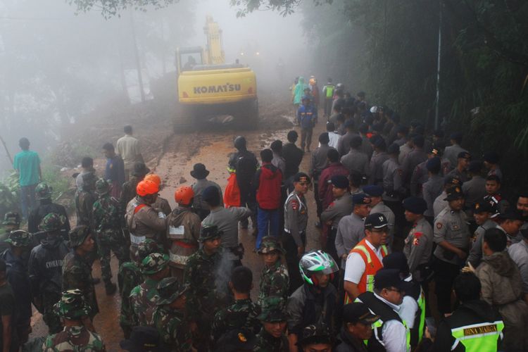 Petugas gabungan TNI-Polri bersama pihak terkait sedang memindahkan material longsor yang menutup badan jalan di Jalur Puncak, tepatnya di Riung Gunung, Desa Tugu Selatan, Kecamatan Cisarua, Kabupaten Bogor, Senin (5/2/2018).