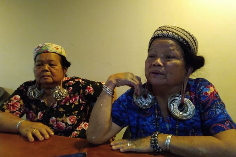 Tipung Ping (baju motif bunga merah) dan Kristina Yeq Lawing (baju biru) perempuan Dayak dengan cuping telinga panjang sebagai simbol kecantikan.