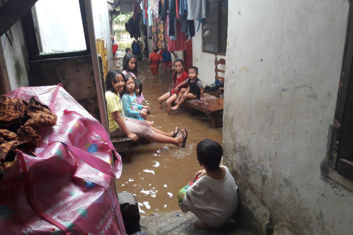 Sejumlah anak tengah bermain di tengah banjir yang melanda kawasan Pejaten Timur, Jakarta Selatan pada Senin (5/2/2018) sore.