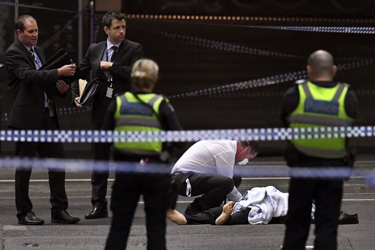 Seorang polisi memeriksa korban tewas dalam insiden penikaman di kota Melbourne, Australia pada Jumat (9/11/2018).