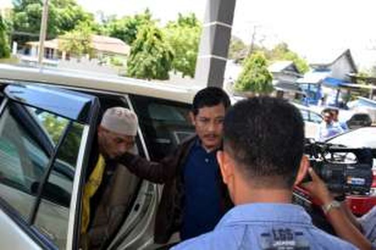 Abdul Halip Bin Muin (berpeci), anggota Kelompok Santoso, turun dari mobil di depan LP Baubau. Ia akan menjalani masa tahanan selama 4 tahun di LP Baubau