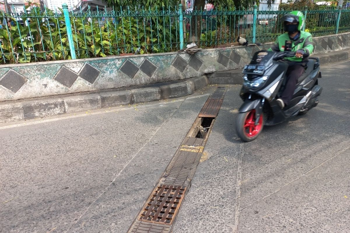 Besi penutup saluran air (grating) di Jalan KH Dewantoro, Pasar Ciputat, Tangerang Selatan, hilang pada Senin(3/7/2023). Diduga grating itu hilang karena tercebur ke dalam selokan.
