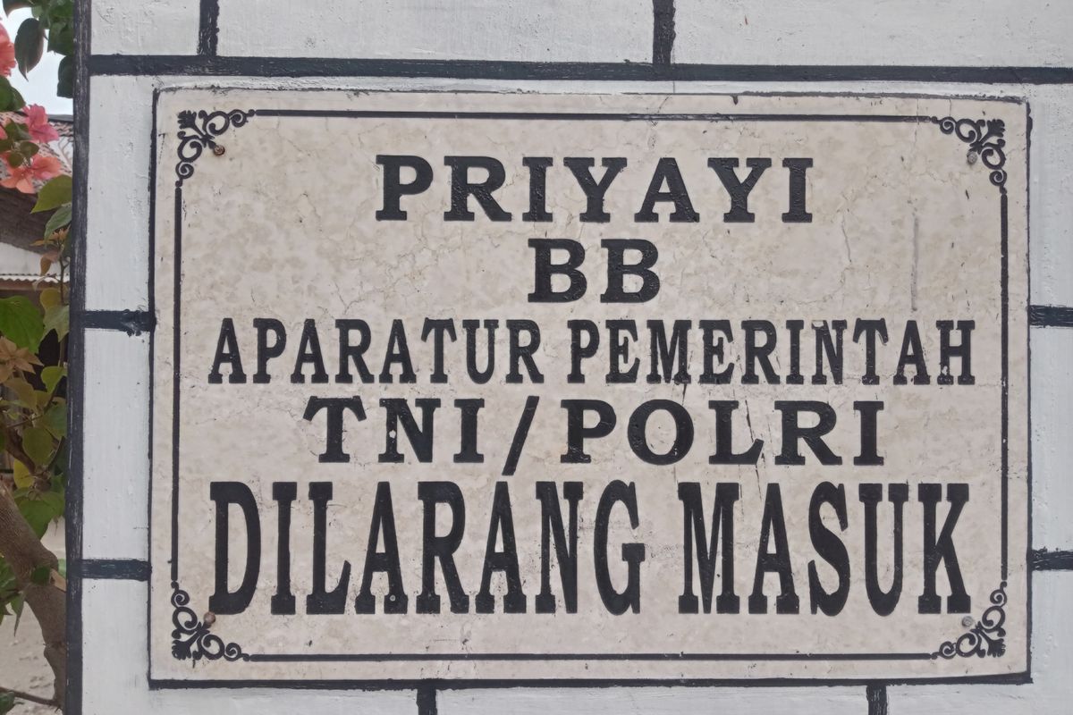 Plakat larangan masuknya pegawai yang terpasang di gapura masuk Dusun Setono, Desa Tales, Kecamatan Ngadiluwih.