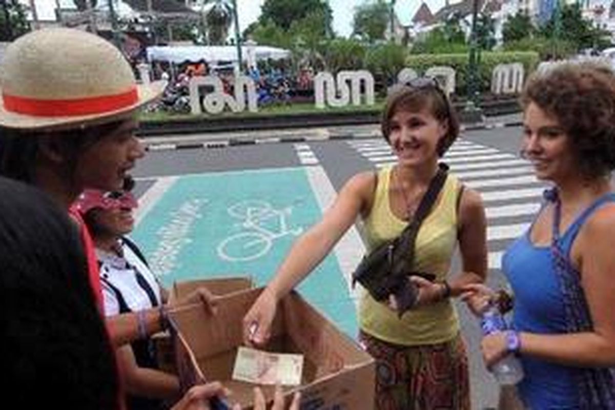 Warga negara asing turut menyumbang pada aksi penggalangan dana yang dilakukan oleh anggota komunitas cosplay dalam kegiatan Jogja Care for Japan di Titik Nol, Yogyakarta, Rabu (23/3/2011). Aksi tersebut dilakukan untuk mengetuk kepedulian masyarakat dalam membantu warga Jepang yang mengalami bencana tsunami dan ancaman radiasi nuklir.