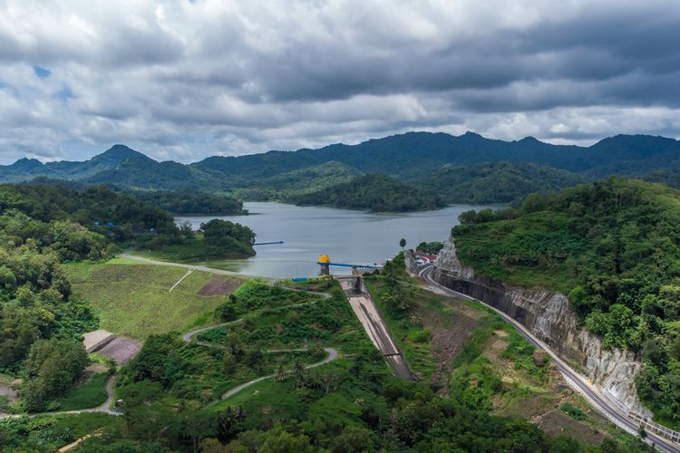 Pemandangan indah Waduk Sermo dengan air yang tenang dan dikelilingi perbukitan hijau