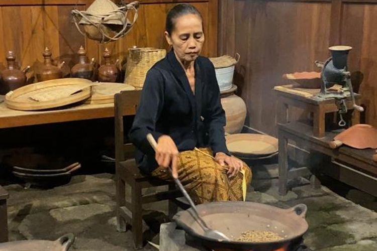 Seorang ibu menyangrai kopi menggunakan wajan tanah liat di Sanggar Genjah Arum Kopai Osing