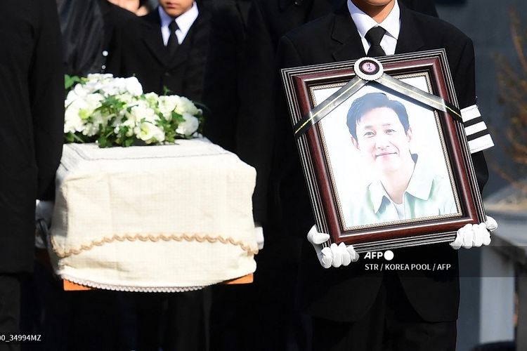 Sambil membawa foto ayahnya, putra sulung Lee Sun Kyun berjalan di depan peti jenazah yang membawa jenazah aktor tersebut dari rumah duka Seoul National University Hospital di Seoul, Korea Selatan, Jumat (29/12/2023).