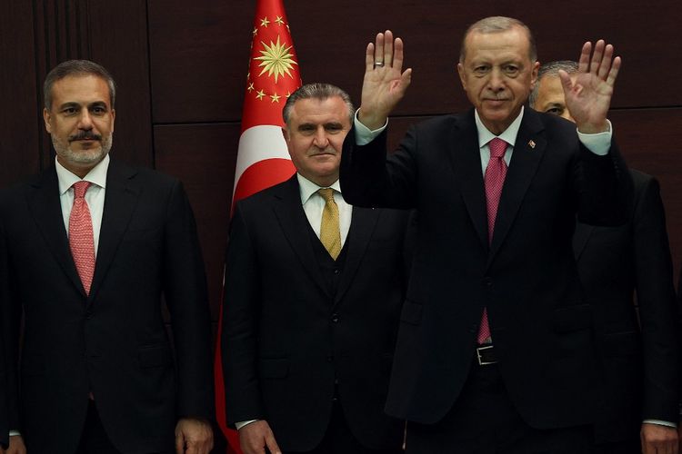 Presiden Turkiye Recep Tayyip Erdogan (kanan) melambaikan tangan di sebelah Menteri Luar Negeri baru Hakan Fidan (kiri) saat ia memperkenalkan kabinet baru negara itu di Istana Cankaya setelah dilantik sebagai Presiden di Parlemen di Ankara pada 3 Juni 2023. 