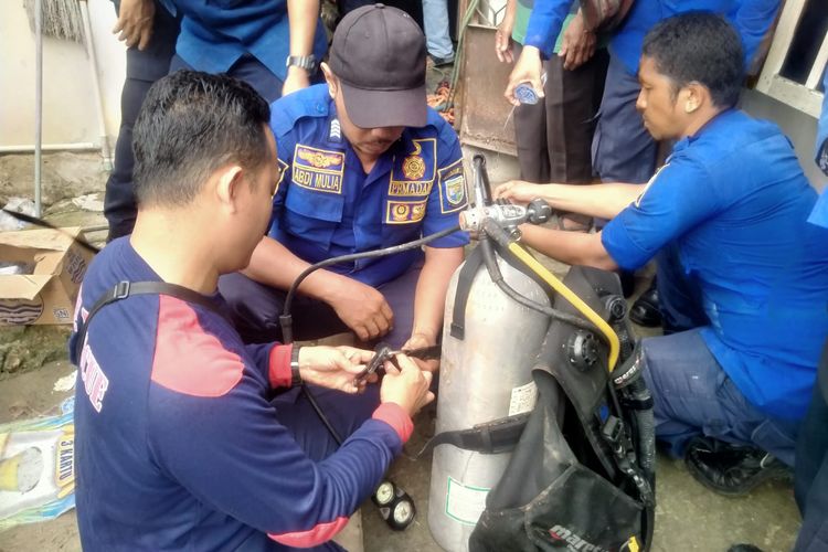 Petugas pemadam kebakaran saat melakukan evakuasi ibu dan anak yang terjebak dalam sumur