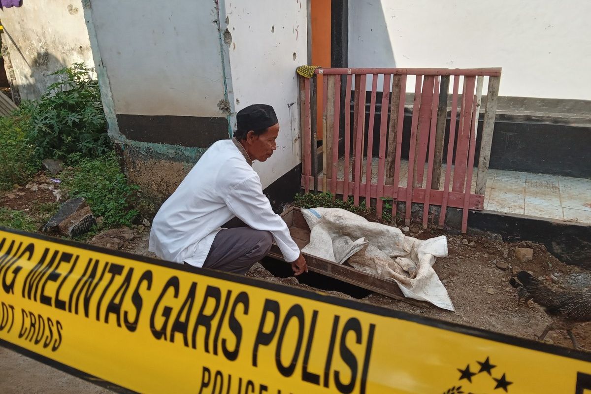 Seorang warga memerlihatkan lobang di pekarangan rumah tersangka pembunuhan berantai Wowon yang dijadikan tempat mengubur korban.