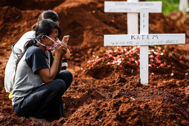 Keluarga berdoa ke jenazah pasien suspect virus corona atau Covid-19 di TPU Pondok Rangon, Jakarta Timur, Kamis (21/5/2020). Pemprov DKI Jakarta telah menyiapkan dua tempat pemakaman umum (TPU) untuk memakamkan pasien terjangkit virus corona (Covid-19) yang meninggal dunia, yakni di TPU Tegal Alur di Jakarta Barat dan TPU Pondok Ranggon di Jakarta Timur. Jenazah yang dapat dimakamkan di sana, yakni yang berstatus pasien dalam pengawasan (PDP) dan berstatus positif terjangkit virus corona.