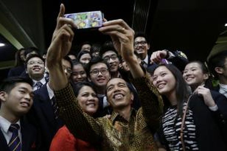Presiden Joko Widodo bersama istrinya, Iriana, bersama siswa di Anglo-Chinese School International di Singapura mengambil 