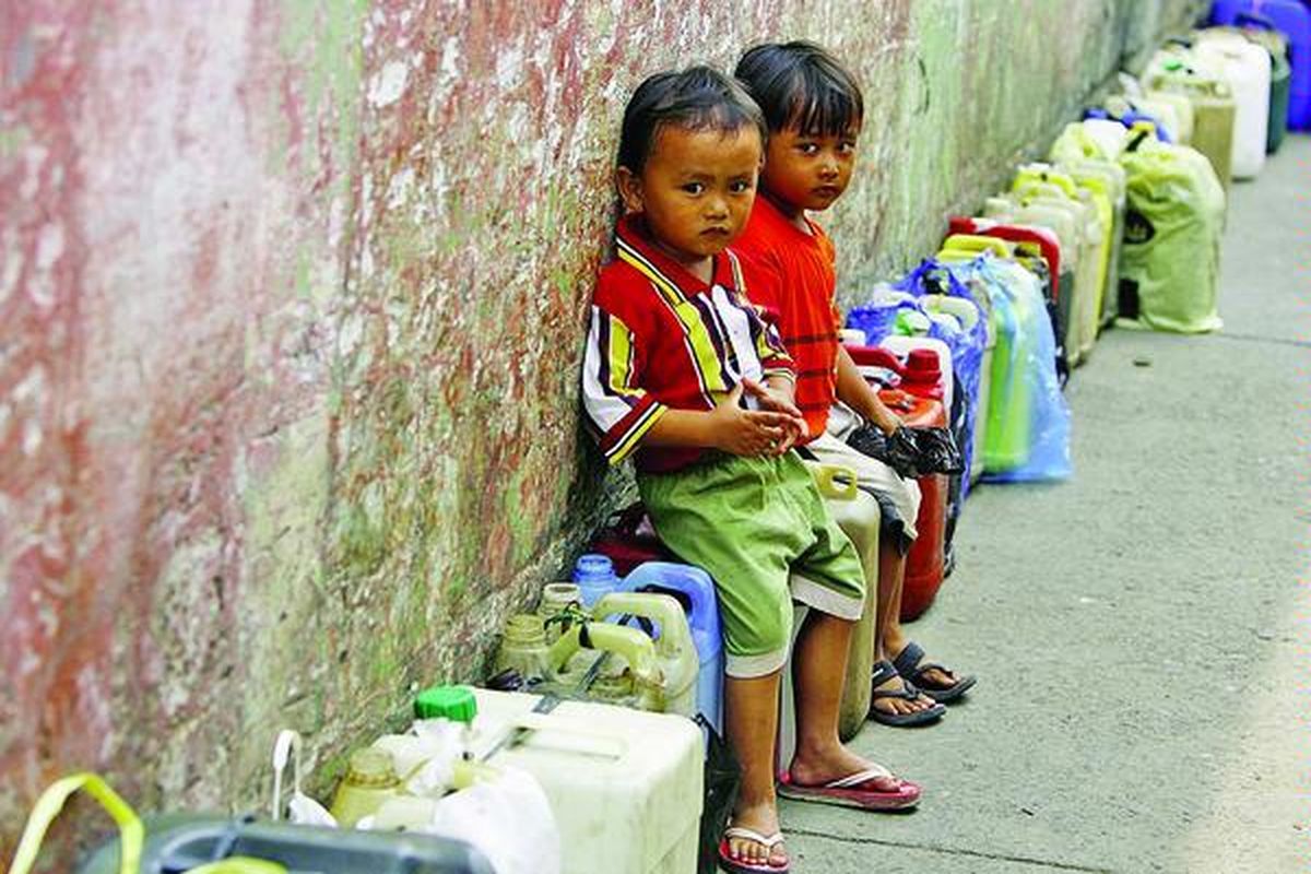 Anak-anak menunggu ibu mereka antre membeli minyak tanah di Jalan Surapati, Bandung, Jawa Barat, Senin (31/3). Setiap ibu rumah tangga dibatasi hanya boleh membeli 5 liter minyak tanah dengan harga Rp 2.300 per liter. Di tingkat eceran di sekitar tempat penjualan, minyak tanah dijual Rp 3.000 per liter.  