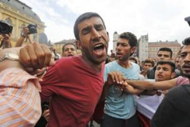 Para migran berdesak-desakan dan saling dorong di stasiun kereta di Budapest, Hungaria, Kamis (3/9/2015). 