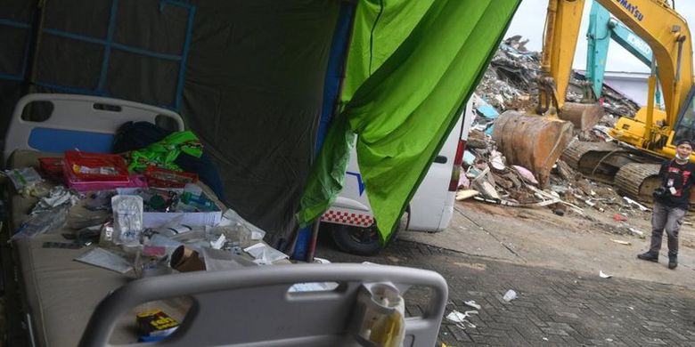 Seorang jurnalis melintas di sisa bangunan Rumah Sakit Mitra Manakarra yang roboh akibat gempa bumi magnitudo 6,2 di Mamuju, Sulawesi Barat, Sabtu (16/1/2021).