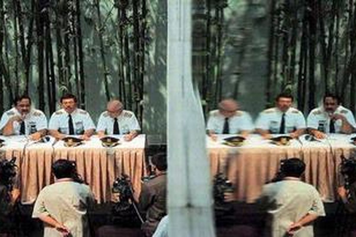 Empat  pilot PT Garuda Indonesia yang mengatasnamakan Pilot Peduli Garuda Indonesia (dari kiri ke kanan), Robert Moningka, Monatar Napitupulu, Joko Sudihartono, dan Rosihan Makmur, terlihat dalam refleksi kaca saat jumpa pers, Selasa (26/7), di Jakarta. Mereka menyikapi rencana pemogokan pilot PT Garuda Indonesia pada Kamis  (28/7) besok. Mereka menyatakan, tidak setuju dengan rencana pemogokan terbang seperti yang disampaikan Asosiasi Pilot Garuda beberapa waktu lalu.