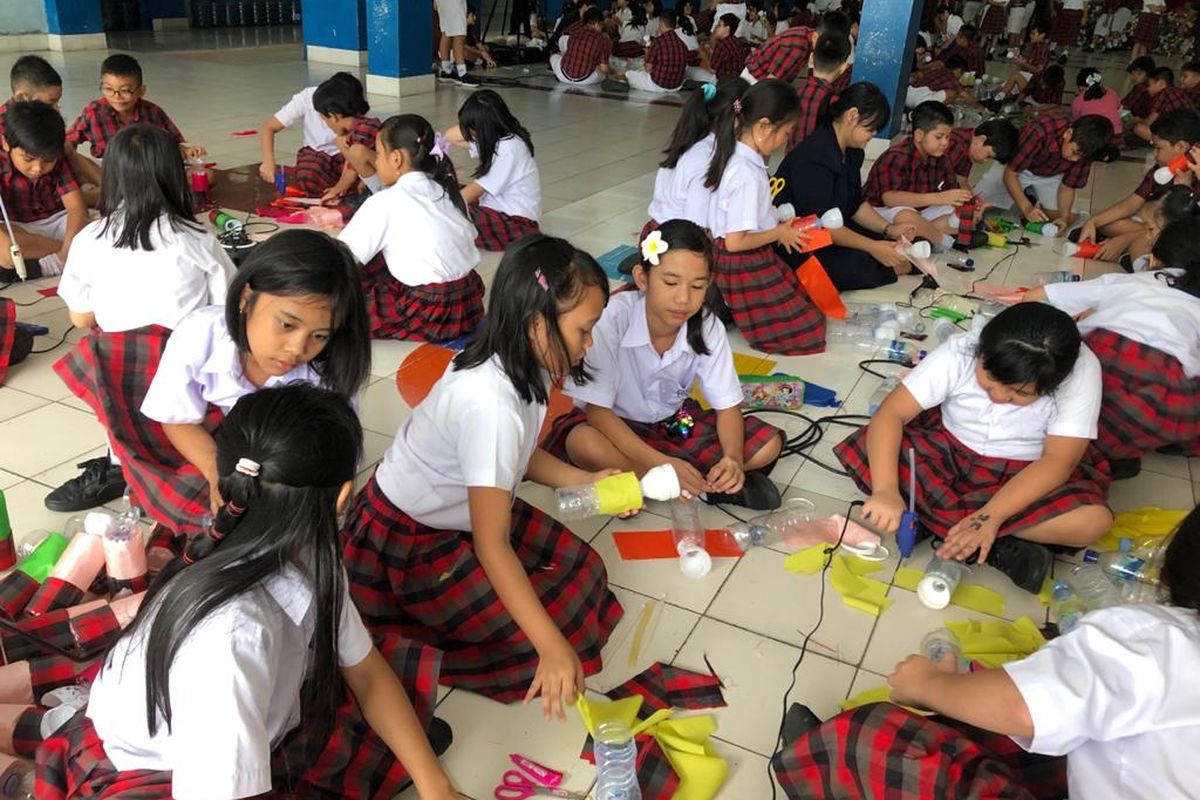 Siswa dan siswi SD Tarakanita saat menghias botol dengan kain perca.