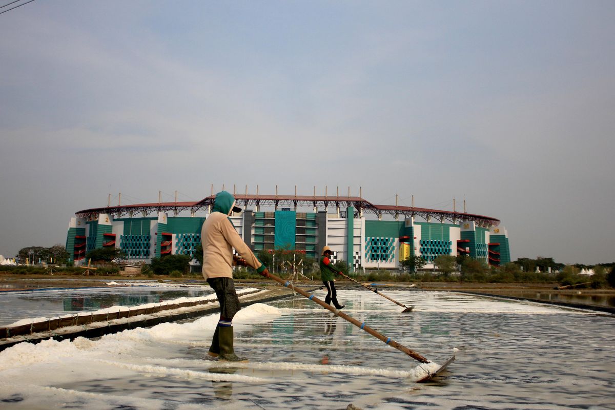Meski dalam persiapan menyambut Piala Dunia U17 2023 Indonesia, sejumlah petani garam tetap melakukan pekerjaannya di tambak yang berada didepan Stadion Gelora Bung Tomo Surabaya, Jawa Timur, Kamis (9/11/2023) siang. 
