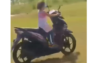Tangkapan layar video bernarasi seorang anak kecil belajar mengendarai sepeda motor.