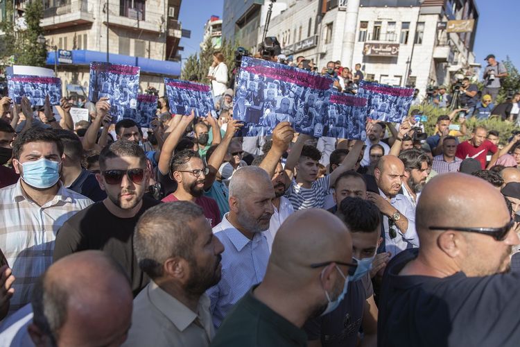 Warga Palestina yang berunjuk rasa menuntut Presiden Palestina Mahmoud Abbas mundur dari jabatan, setelah kematian aktivis Nizar Banat. [AP Photo/Nasser Nasser]