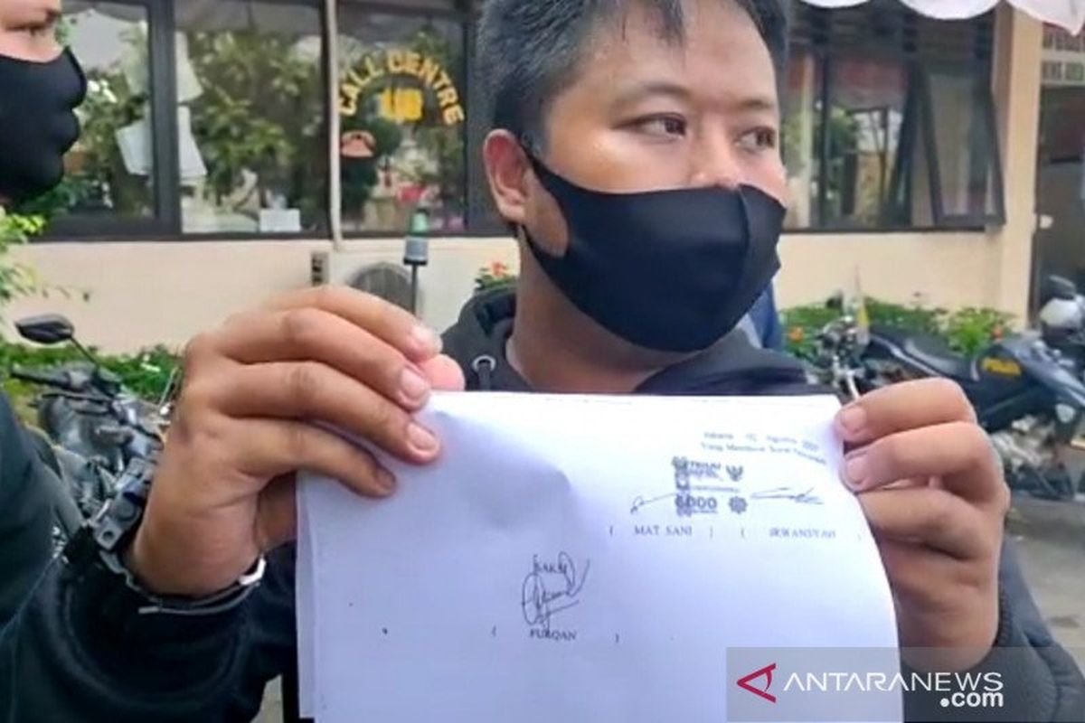 Petugas Dinas Perhubungan berinisial IR memperlihatkan selembar kertas yang disebut sebagai surat perdamaian dengan seorang pengendara angkot di halaman parkir Mapolsek Pulo Gadung, Jakarta Timur, Minggu (2/7/2020). Perikaian anggota Dishub dan pengendara angkot dipicu senggolan sehingga berujung pemecahan kaca kendaraan.