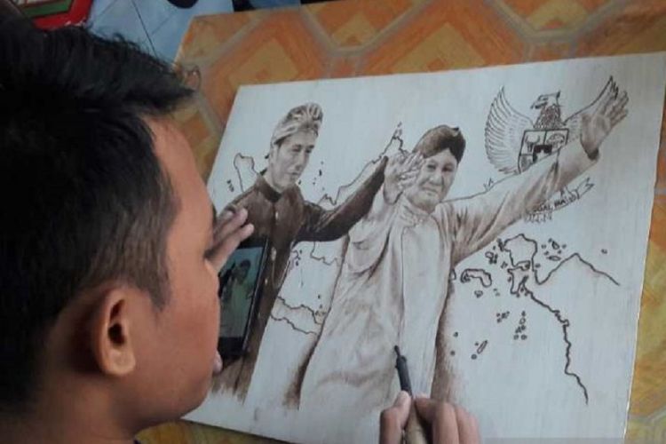 Pelukis muda Temanggung mengabadikan calon presiden Joko Widodo dan Prabowo Subianto bergandeng tangan saat deklarasi kampanye damai Pemilu 2019 dalam lukisan pyrography.