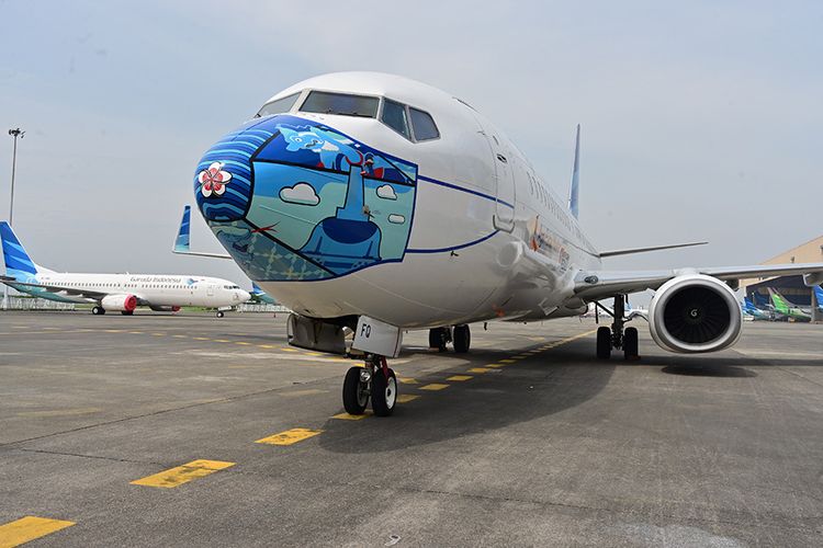 Pesawat Garuda Indonesia Boeing 373-800 NG dengan desain masker di bagian depan pesawat, saat diparkir di lapangan udara di Tangerang, Banten, Senin (12/10/2020). Pemasangan ''masker'' di pesawat tersebut digelar untuk mendukung kampanye Gerakan 'Ayo Pakai Masker' dalam rangka penanggulangan pandemi Covid-19.