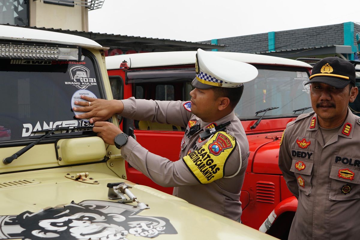 Kasatlantas Polres Pasuruan AKP. Deni Eko sedang menempelkan stuker usai melakukan pengecekan jeep hardtop yang biasa beroperasi di kawasan wisata Gunung Bromo,  Jum'at (6/12 /2024) 