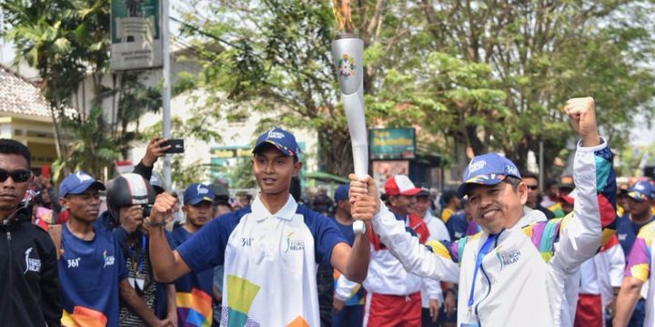 Ketua KONI Kabupaten Purwakarta Dedi Mulyadi saat menerima obor Asian Games dari seorang pelari di Purwakarta, Jawa Barat, Jumat (10/8/2018).