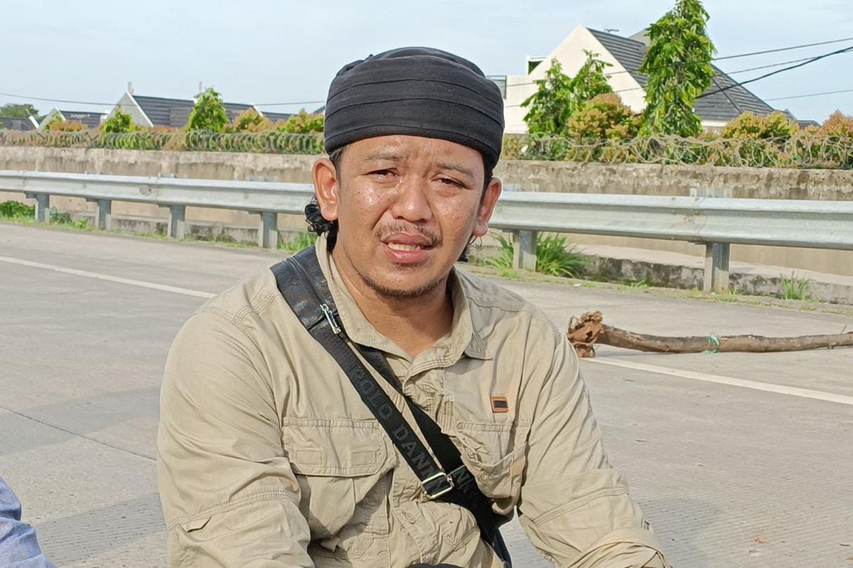 Salah satu ahli waris pemilik sah lahan akses Tol Jatikarya ruas Cimanggis-Cibitung, Sulaeman Pembela (33), yang menangis di tengah aksinya memblokade GT Jatikarya, Senin (10/4/2023). Aksi ahli waris tersebut diketahui bukan pertama kali dilakukan oleh warga.