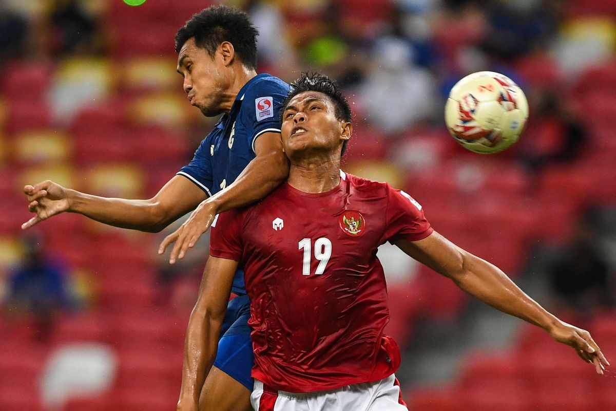 Pemain Thailand Teerasil Dangda (kiri) beradu sundulan di udara dengan pemain Indonesia Fachruddin Wahyudi Aryanto pada pertandingan leg kedua final Piala AFF 2020 antara Indonesia vs Thailand di National Stadium, Singapura, Sabtu (1/1/2022) malam WIB. Indonesia kembali berjumpa Thailand pada laga fase grup Piala AFF 2022. Laga Indonesia vs Thailand akan bergulir di Stadion GBK pada Kamis (29/12/2022). Thailand akan mendapatkan bonus jika menang melawan Indonesia.