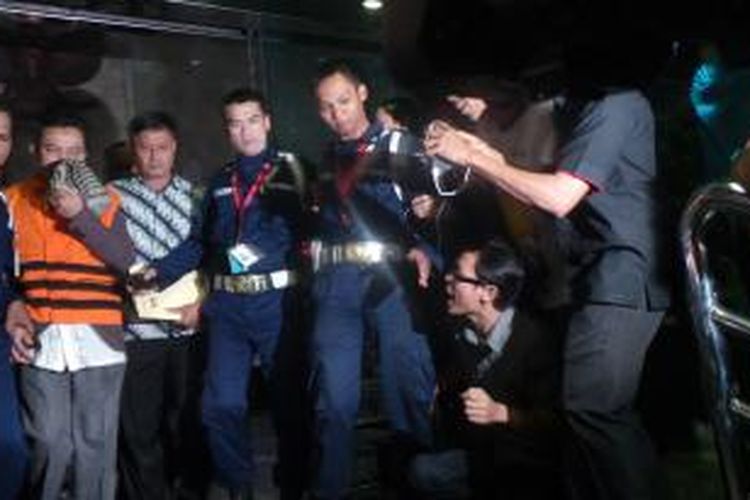 Bupati Karawang Ade Swara (mengenakan rompi tahanan) keluar dari Gedung KPK untuk dibawa ke tahanan, Jumat (18/7/2014) malam.