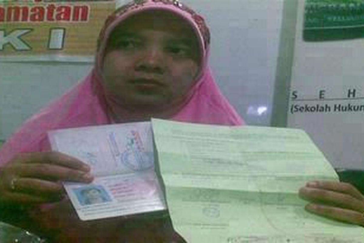 Rusmini menunjukkan surat kontrak kerja yang dipalsukan oleh PJTKI yang mengirimnya, Kamis (7/7/2011).